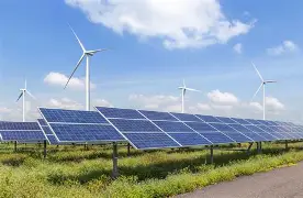 Solar panel arrays with a windmill in the background.
